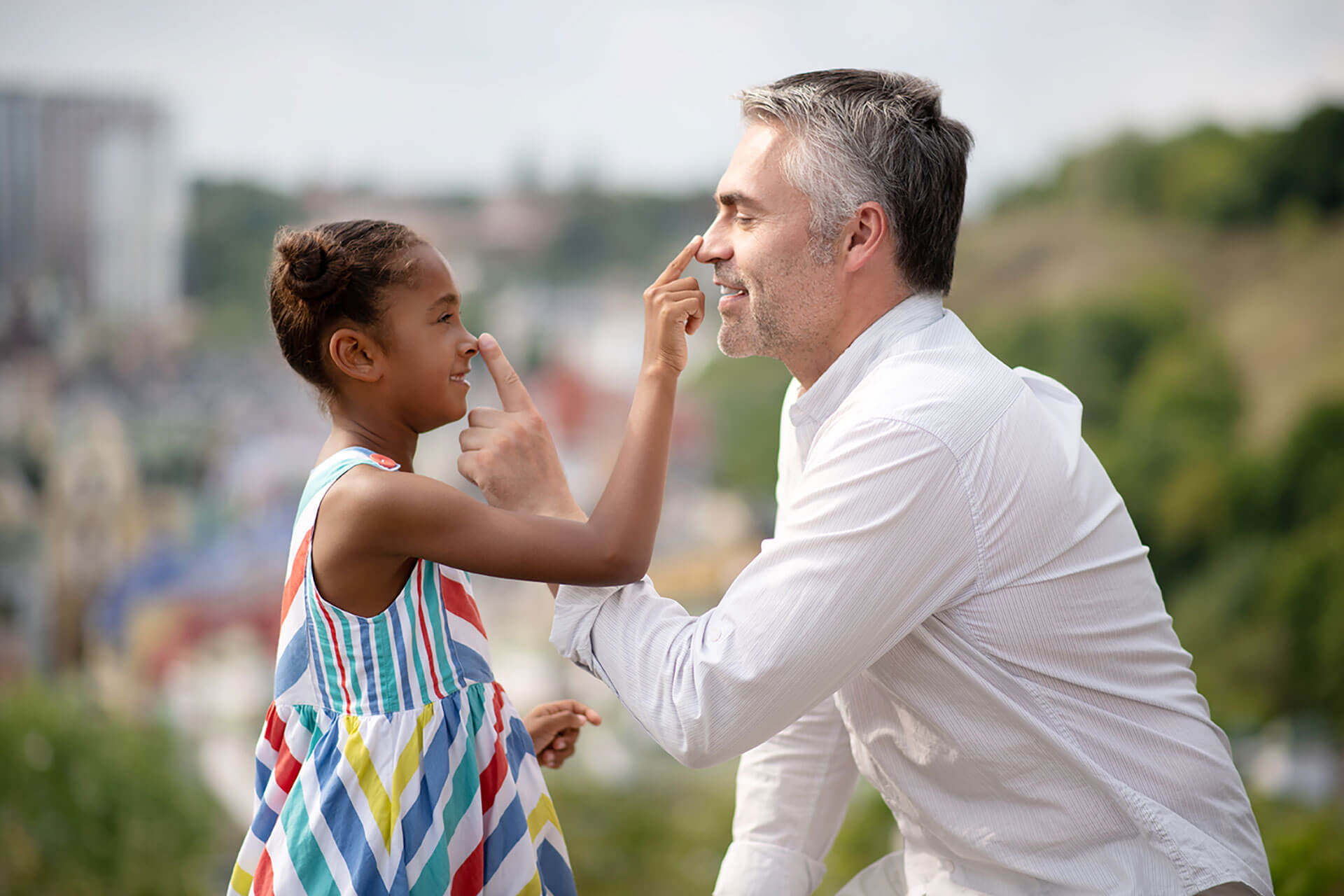 African american daughter touching nose of her foster parent